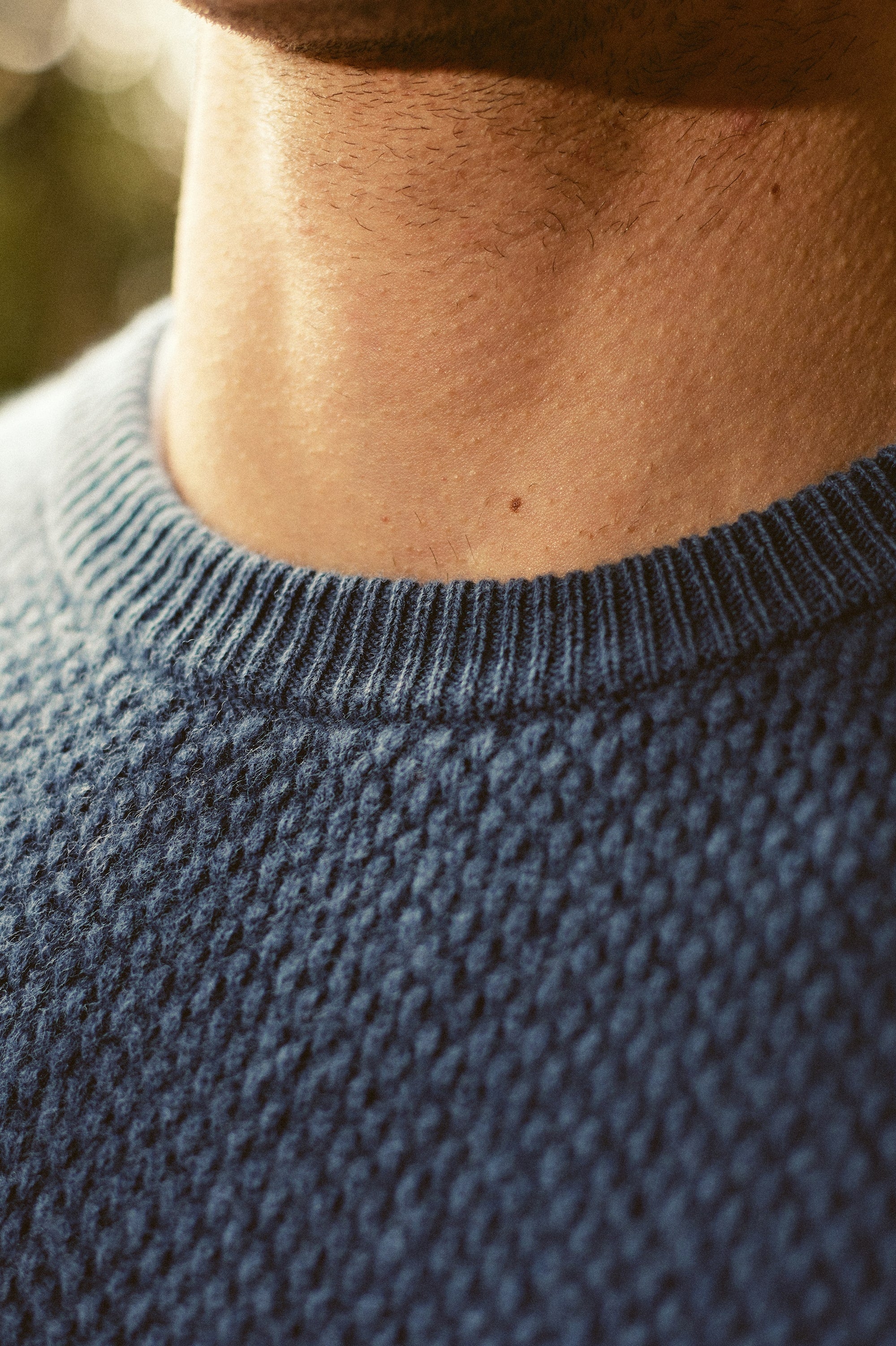a close up of a man wearing a blue sweater