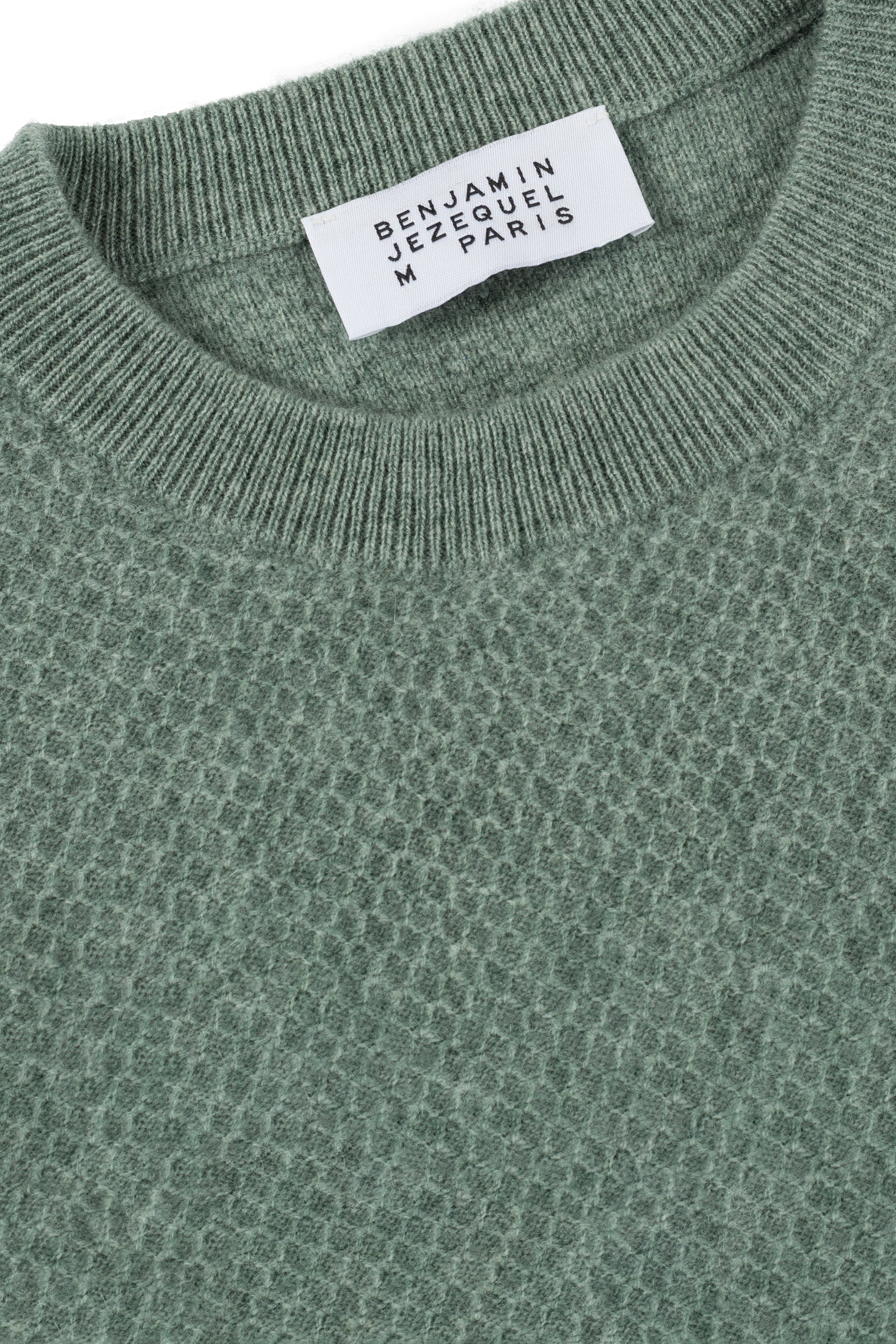 a green sweater with a tag on it