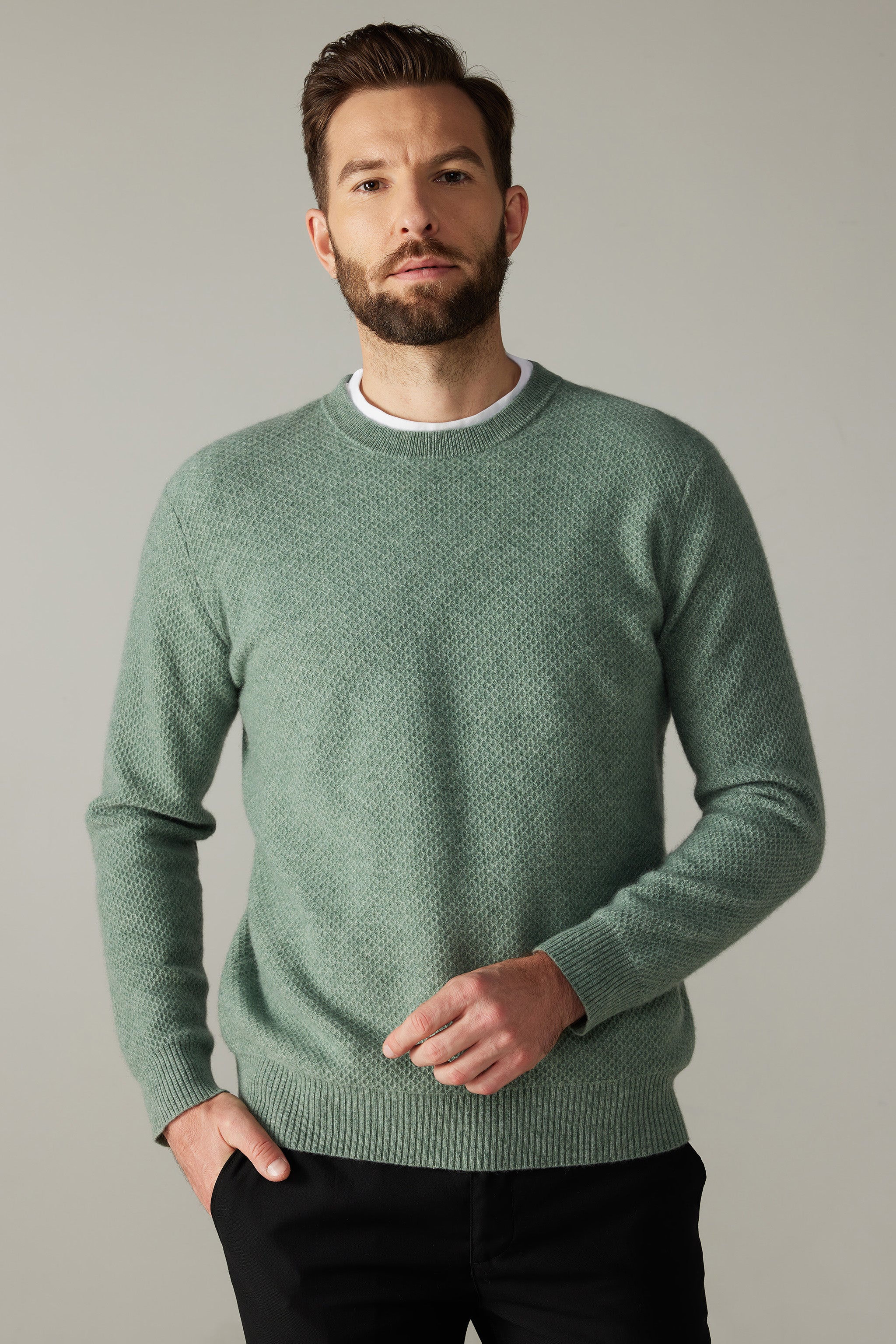 a man with a beard wearing a green sweater