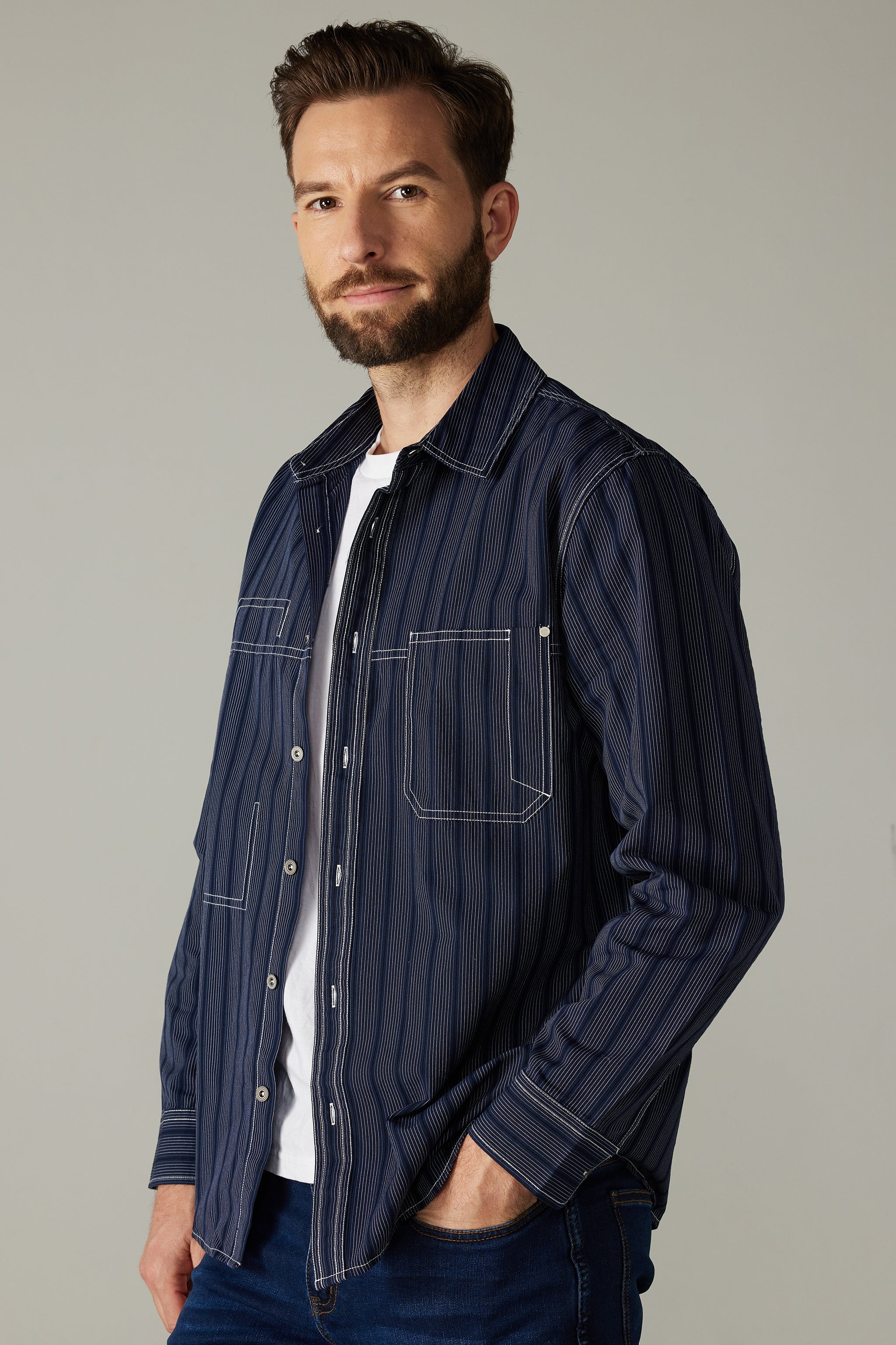 a man with a beard wearing a shirt and jeans